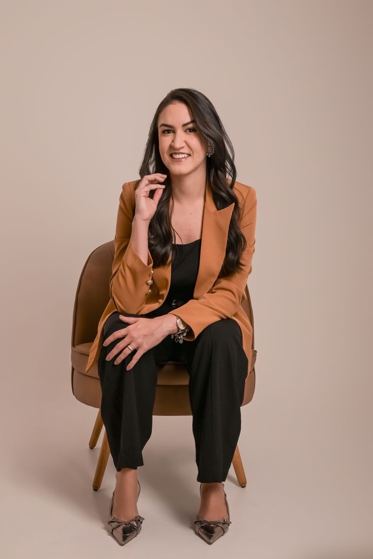 Dra. Carol sentada em poltrona